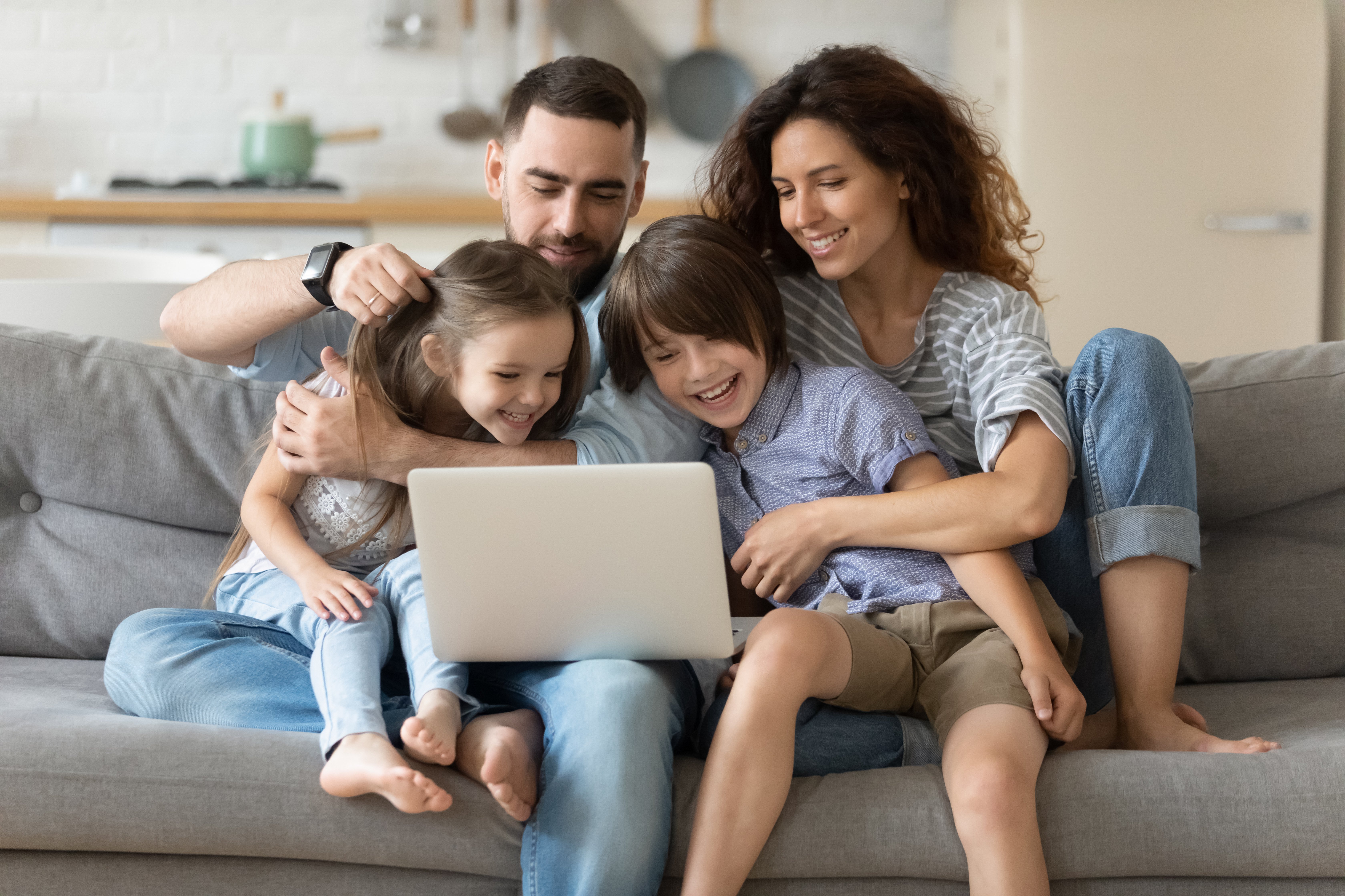 HAPPY FAMILY WATCHING SOMETHING ON A LAPTOP